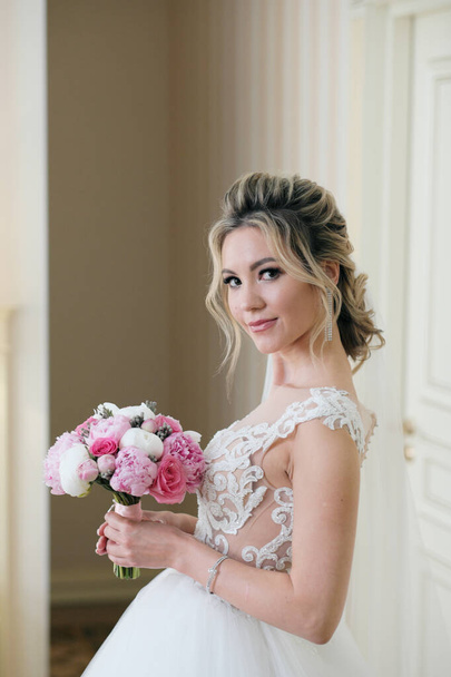 Blonde woman in wedding dress with bouquet - Zdjęcie, obraz