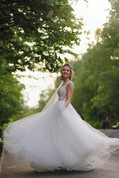 Bella sposa bionda in posa nel giardino primaverile
 - Foto, immagini