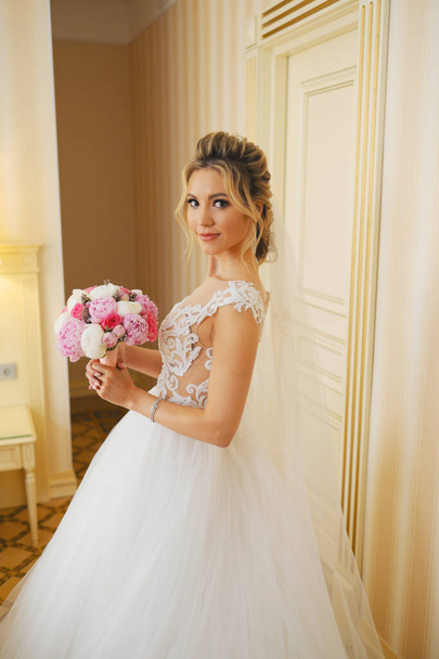 Blonde woman in wedding dress with bouquet - Foto, immagini