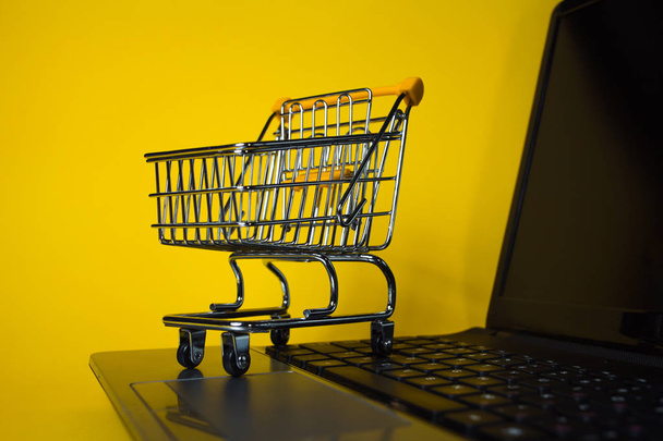 End of online sales. Online shopping, shopping cart on laptop keyboard. - Photo, Image