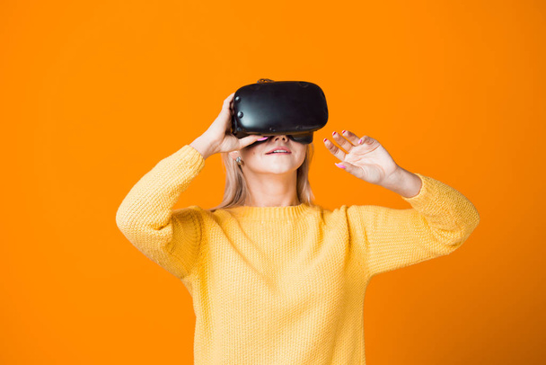 Computer game player uses virtual reality. A young woman in a virtual reality helmet - Photo, Image