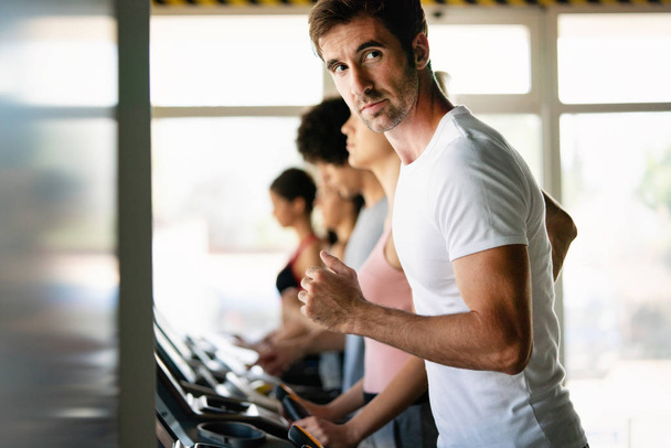 Fit happy people running in machine treadmill at fitness gym - Zdjęcie, obraz