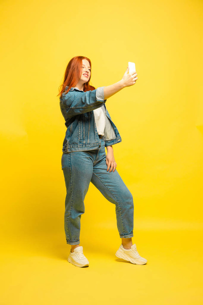 Caucasian womans portrait isolated on yellow studio background, follower be like - 写真・画像