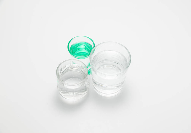 transparent glasses and one green glass with water - Фото, зображення