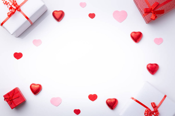 Der Hintergrund des Valentinstages. mit Geschenken und Herzen, in rot und weiß, Draufsicht. san valentin und liebe konzept. - Foto, Bild