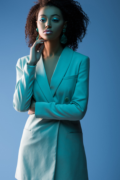 attractive african american woman in suit isolated on blue - Fotó, kép