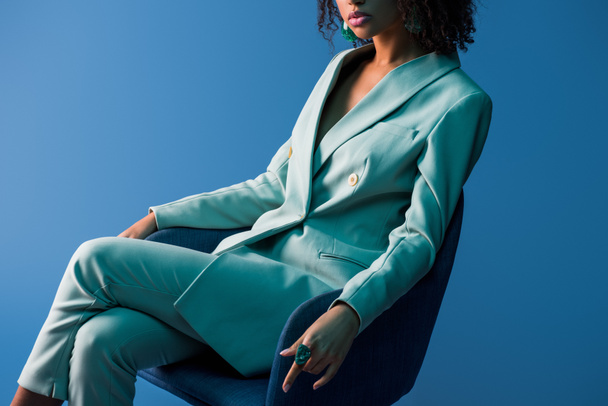 vue recadrée de femme afro-américaine assise sur un fauteuil isolé sur bleu
 - Photo, image