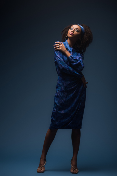 attractive african american woman looking up on blue background - Fotoğraf, Görsel