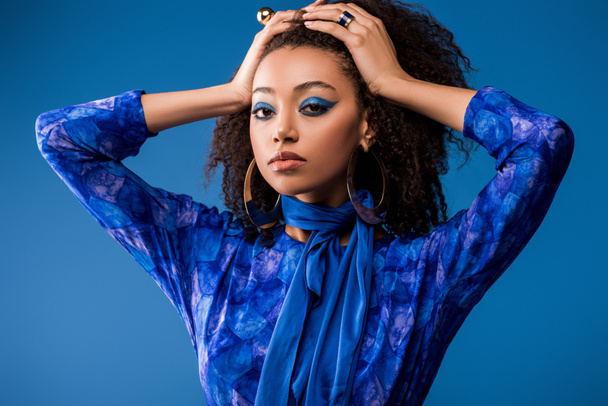 stylish african american woman in dress looking at camera isolated on blue  - Foto, Imagem