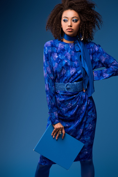 attractive african american woman holding folder isolated on blue  - Photo, Image