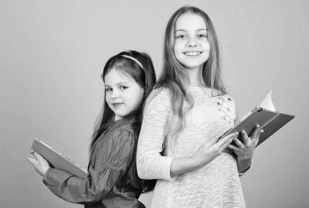 Opening doors through literacy. Kids girls with books or notepads. Education and kids literature. Favorite fairytale. Back to school. Sisters pick books to read together. Adorable girls love books - Foto, imagen