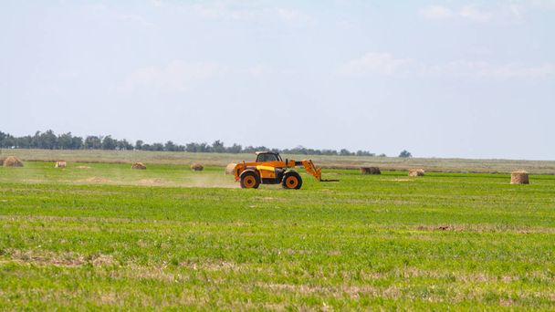 Traktor szénabálák rakodása tehergépkocsira mezőgazdasági munkák - Fotó, kép