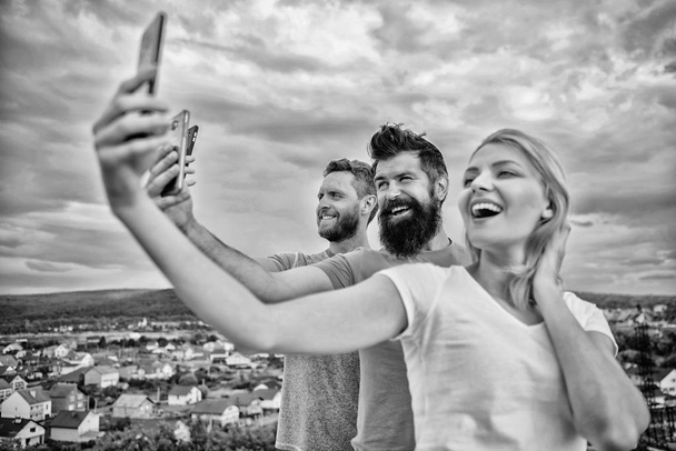 Girl and man with mobile smartphones communication online. Selfie time. Life online. People taking selfie or streaming online video. Mobile internet and social networks. Mobile dependency problem - Foto, afbeelding