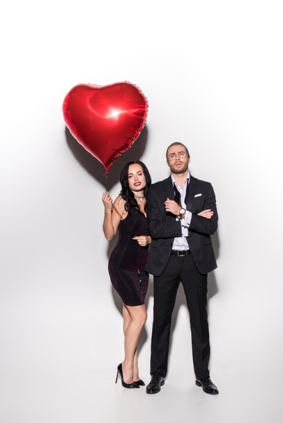 smiling couple holding red heart shaped balloon on valentines day on white - Foto, Imagem