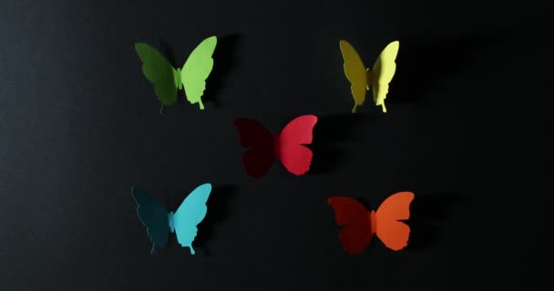 Stop beweging van papieren vlinders op een donkere achtergrond. - Video