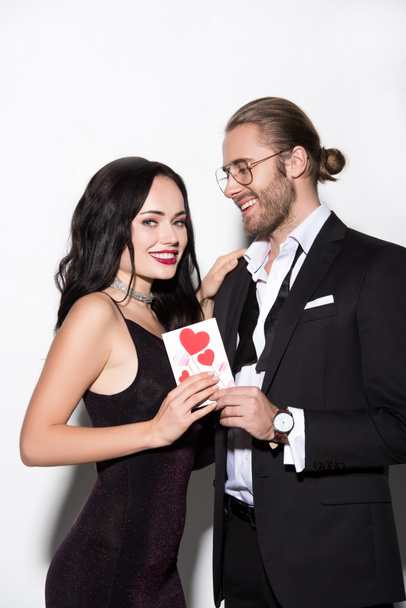 cheerful young couple holding valentines day card on white - Foto, Imagem