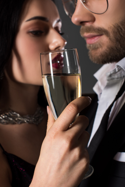 selective focus of beautiful couple holding glass of champagne on valentines day, isolated on grey - Photo, Image