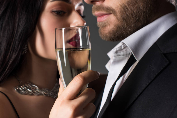 tender couple holding glass of champagne on valentines day, isolated on grey - Foto, Imagen