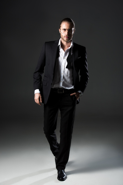 confident handsome man posing in suit on grey - Fotoğraf, Görsel