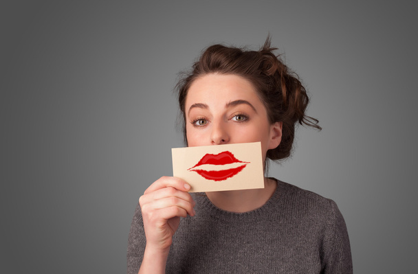 Happy pretty woman holding card with kiss lipstick mark - Photo, Image