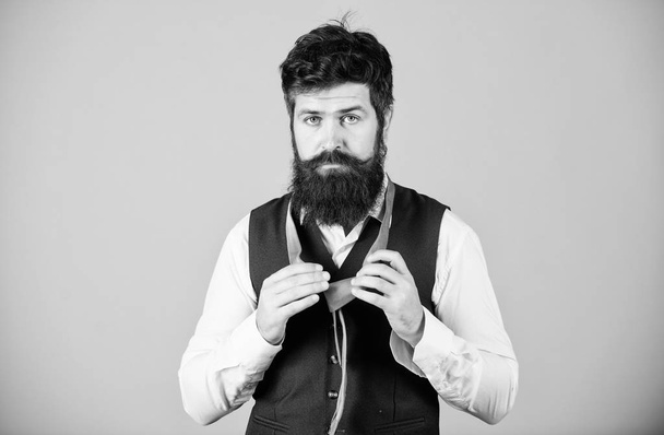 Quite formal. Fashionable man. Bearded man tying a necktie. Brutal caucasian man adjusting fashion accessory. Man with long beard and moustache dressing in classic style - Foto, Imagen