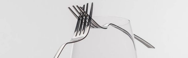 Panoramic shot of two forks on wine glass isolated on grey - Valokuva, kuva