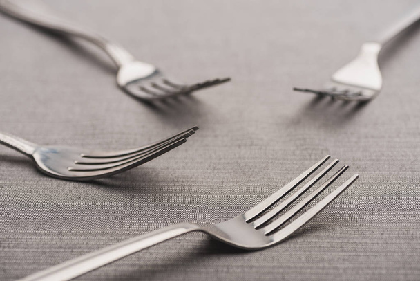 Selective focus of shiny forks of grey tablecloth - Fotografie, Obrázek