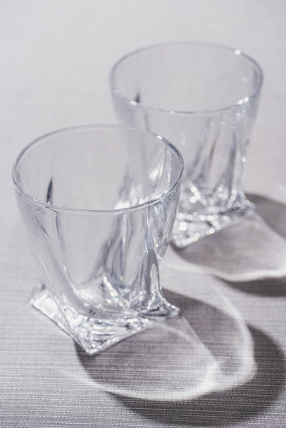 Transparent glasses with shadow on grey surface - Valokuva, kuva