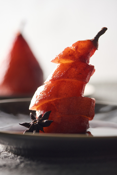 close up view of delicious sliced pear in wine with anise on plate - 写真・画像