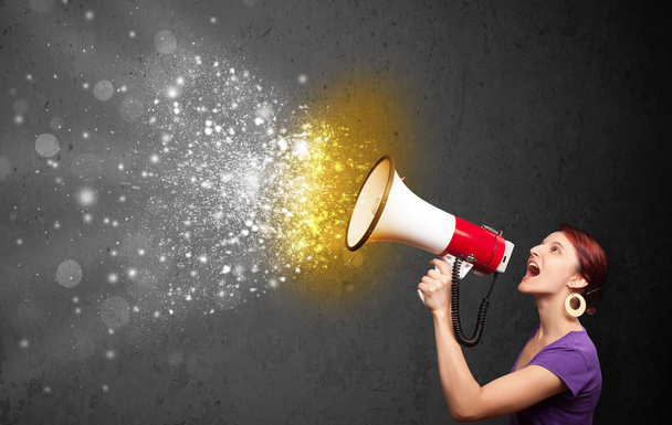 Woman shouting into megaphone and glowing energy particles explo - Zdjęcie, obraz