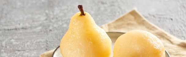 delicious pear in wine served on plate on napkin on grey concrete surface, panoramic shot - 写真・画像