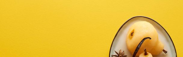 top view of delicious pear in wine with anise on plate on yellow background, panoramic shot - Foto, Bild