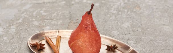 delicious pear in wine with cinnamon and anise on silver plate on grey concrete surface, panoramic shot - Фото, зображення