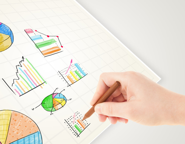 Business person drawing colorful graphs and icons on paper - Photo, Image