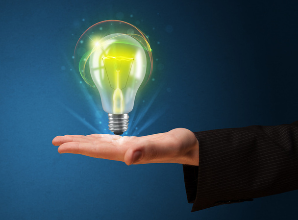 Glowing lightbulb in the hand of a businessman - Photo, Image