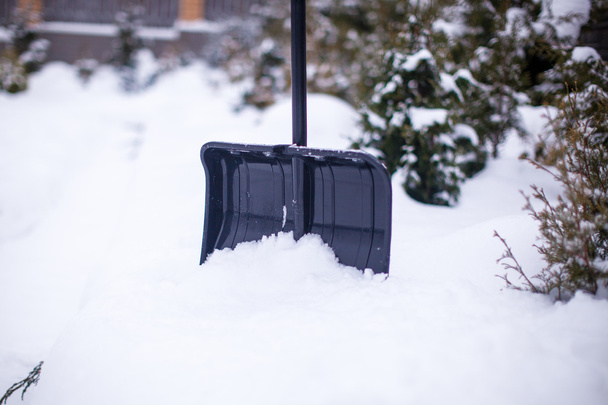 Металлическая лопата в большом снежном заносе в зимний день
 - Фото, изображение