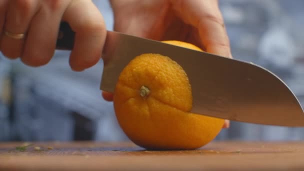 Close-up of cut orange on a board in the kitchen on a wooden board. - Πλάνα, βίντεο