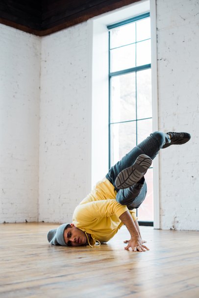 stylish man in hat breakdancing in dance studio  - Фото, зображення