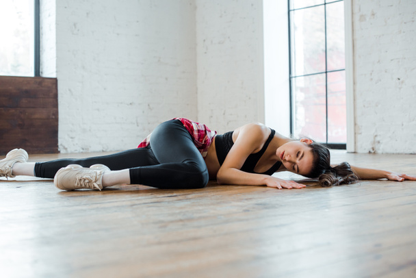 jolie fille couchée sur le sol tout en dansant jazz funk en studio de danse
  - Photo, image