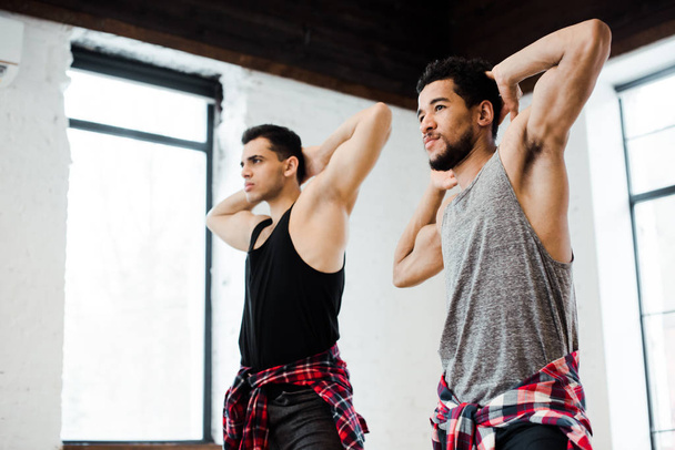dançarinos multiculturais musculares posando enquanto dançam jazz funk no estúdio de dança
  - Foto, Imagem