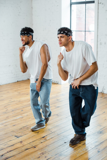 przystojny wielokulturowe tancerze w headbands taniec hip-hop - Zdjęcie, obraz