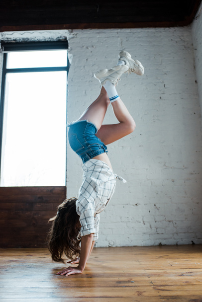 young dancer doing handstand in dance studio  - Photo, Image
