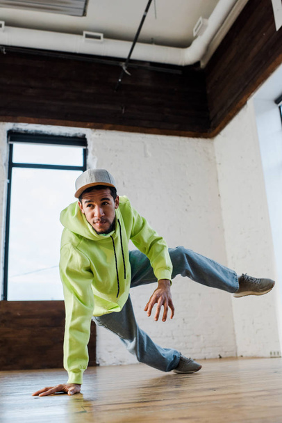 stylish and young african american man in cap breakdancing in dance studio  - Fotoğraf, Görsel