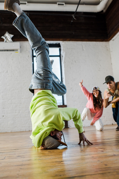 foyer sélectif de l'homme afro-américain en casquette breakdance près des danseurs émotionnels
  - Photo, image