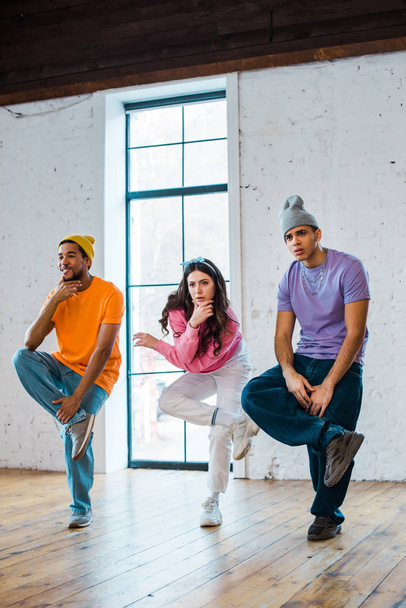 stylish woman and multicultural men breakdancing - Photo, Image