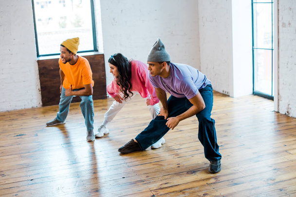 jeune femme et hommes multiculturels élégants en studio de danse
  - Photo, image