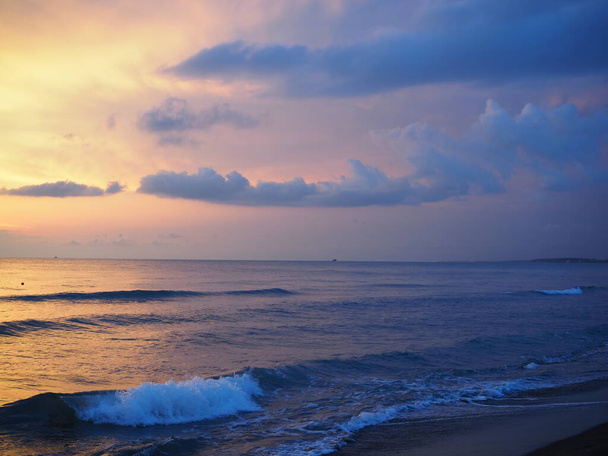 Rudý západ slunce nad mořem, bohatý na tmavé mraky, paprsky světla - Fotografie, Obrázek