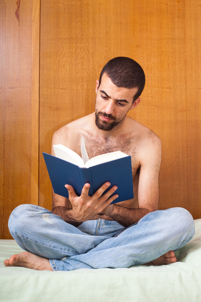 Man reading a book on the bed - Φωτογραφία, εικόνα