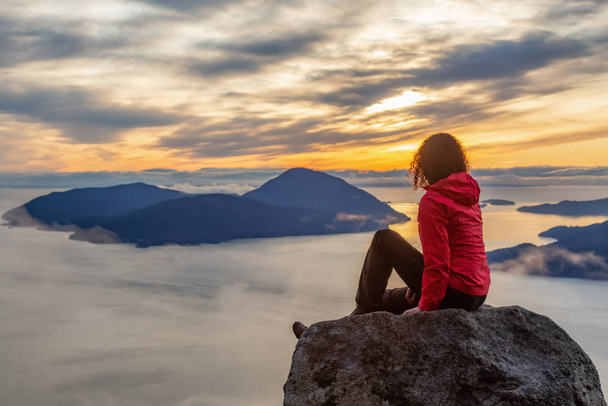Kalandos lány a hegy tetején naplementekor - Fotó, kép