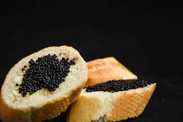 three tasty sandwiches with black caviar on the dark background - Photo, Image